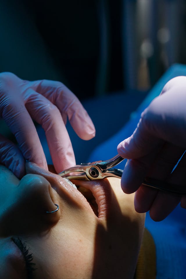 A patient's having their mouth worked on by a dentist with tools