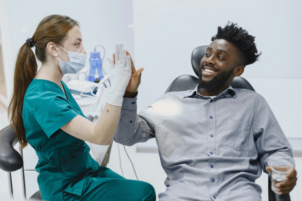 A dentist and her patient doing a high five