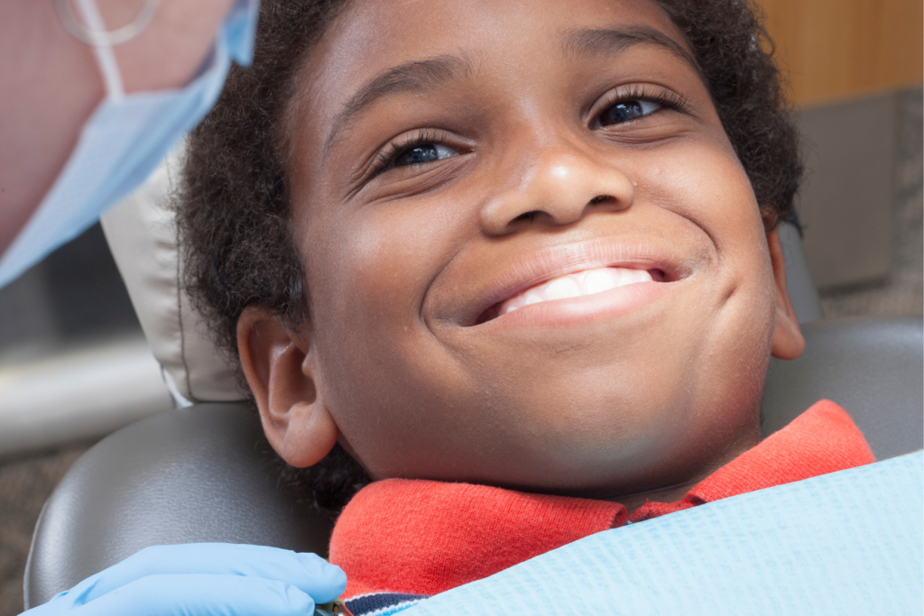 A boy smiling in a dental chair