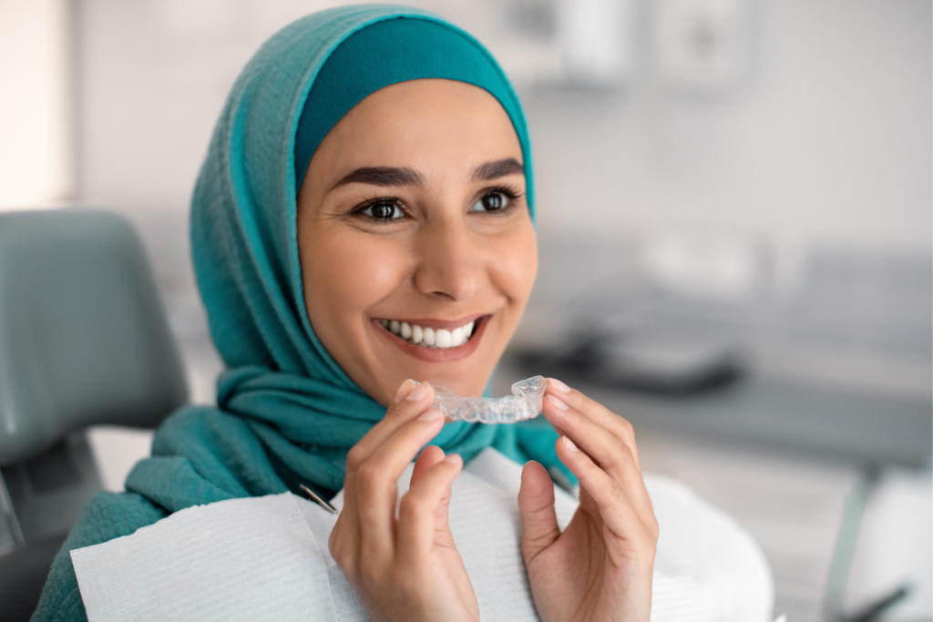 A woman holding her aligner